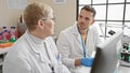 Two scientists, a man and a woman, engage in a discussion in a well-equipped laboratory, suggesting teamwork and analysis Royalty Free Stock Photo