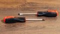 Two screwdrivers with different tips lie on a wooden table Royalty Free Stock Photo
