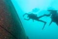 Two SCUBA divers exploring shipwreck remains, silhouettes from below divers Royalty Free Stock Photo