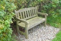 Two seater park bench set on gravel with hedgerow behind Royalty Free Stock Photo