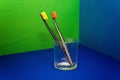 Two selective focus toothbrushes in a transparent glass on a colored background Royalty Free Stock Photo