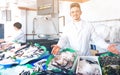 Two sellers posing near display with frozen fish Royalty Free Stock Photo