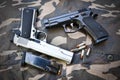 Two semi-automatic handguns on camouflage soldier pant Royalty Free Stock Photo