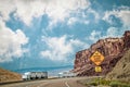 Two semi trailer trucks withthree trailers each - one broken down in canyonlands of Utah USA with sign 6% grades and sharp curves