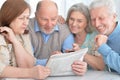 Two senior couples reading newspaper Royalty Free Stock Photo