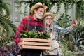 Two senior gardeners, man and woman in straw hats and checkered shirts, making photo together on smartphone or having