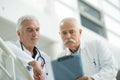 two senior male doctors conferring