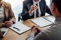 Two senior manager reading a resume during a job interview, Employer interviewing to ask young male job seeker for recruitment ta Royalty Free Stock Photo