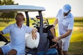 Two senior men golfers on court. Man sitting in golf cart.  Completed round of golf Royalty Free Stock Photo