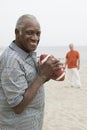 Two senior men playing american football on beach Royalty Free Stock Photo