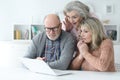 Two senior surprised women and man using laptop at home Royalty Free Stock Photo