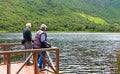 Two senior tourists at the mountain shore lake
