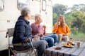 Two senior woman and teenager talking and leisure in camping, activity recreation and leisure picnic while breakfast. Royalty Free Stock Photo