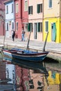 Two Senior woman walking along waterways with traditional colorful facade of Burano and reflection. Venice Royalty Free Stock Photo