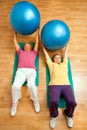 Two senior women doing gym ball exercises on floor. Royalty Free Stock Photo