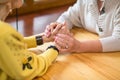 Two senior women holding hands.