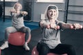 Two senior women stretching out hands with dumbbells Royalty Free Stock Photo