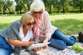 Two Senior Women Using Digital Tablet in Park Royalty Free Stock Photo