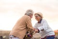 Two seniors together smiling and enjoying looking each other - mature woman with a bike looking at the pensioner man with love