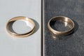 Two separate wedding rings on a black and white background. Concept - differences, opposites, and separation.