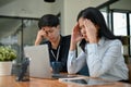 Two serious Asian office workers are focusing on their co-project together Royalty Free Stock Photo