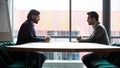 Two businessmen sitting opposite at table, confrontation and negotiation Royalty Free Stock Photo