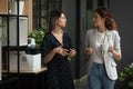 Serious diverse female colleagues talking walking in office space Royalty Free Stock Photo