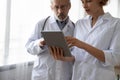 Two serious doctors discussing data using digital tablet Royalty Free Stock Photo