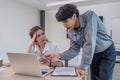 Two serious and stressed Asian office workers are focusing on their co-project together, planning and finding solutions Royalty Free Stock Photo