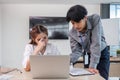 Two serious and stressed Asian office workers are focusing on their co-project together, planning and finding solutions Royalty Free Stock Photo