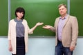 Two serious teachers a man and a woman in a classroom Royalty Free Stock Photo