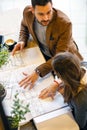 Two young architects discussing building plans during a meeting in a modern cafe Royalty Free Stock Photo