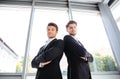 Two serious young businessmen standing with arms crossed in office Royalty Free Stock Photo