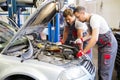 Two servicemen in a car workshop Royalty Free Stock Photo