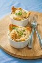 Two servings of baked eggs on a wooden board