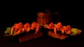 Two servings of delicious appetizing crayfish on improvised plates of rough bark and ceramic beer mug on black background. Concept