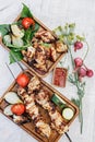 Two servings of delicious charcoal shashlik. Fried meat on a wooden plate. Grilled meat on skewers, baked vegetables and sauce. Royalty Free Stock Photo