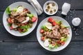 Two servings of grilled meat and salad with vegetables, mozzarella and herbs. Traditional Mediterranean Cuisine