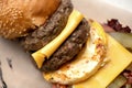 Two servings of grilled meats, double cheese and scrambled eggs in hearty cheeseburger. Double meat and cheese burger