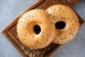 Two sesame bagels on wooden board