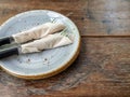 Two set of clean fork and knife wrapped in tissue napkin in the ceramic dish Royalty Free Stock Photo