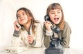 Two seven year old girls talking on the old vintage phones with