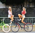 Two girls on a bicycles. Outdoor fashion portrait Royalty Free Stock Photo