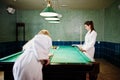 Two sexy girls in white bathrobe play pool billiards Royalty Free Stock Photo