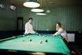 Two sexy girls in white bathrobe play pool billiards Royalty Free Stock Photo