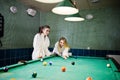 Two sexy girls in white bathrobe play pool billiards Royalty Free Stock Photo