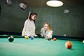 Two sexy girls in white bathrobe play pool billiards Royalty Free Stock Photo