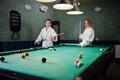 Two sexy girls in white bathrobe play pool billiards Royalty Free Stock Photo