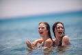 Two Young Girls having fun at the beach inside the sea Royalty Free Stock Photo