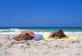 Two young girls laying on a sunny beach on vacation or holi Royalty Free Stock Photo